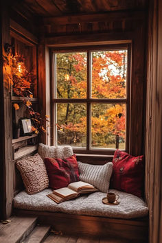 a window seat with pillows and a book on it