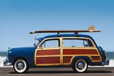 an old car with a surfboard on the roof