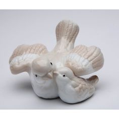 two white ceramic birds sitting next to each other