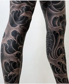 a person with black and grey tattoos on their legs