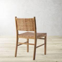 a wooden chair sitting on top of a hard wood floor next to a white wall