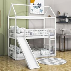 a white bunk bed with a slide next to it in a room filled with furniture