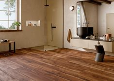 a bathroom with wooden floors and white walls