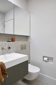 a white toilet sitting next to a bathroom sink