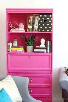 a pink bookcase with books on it