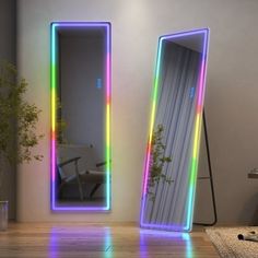 there are two mirrors in the room with lights on them and one has a plant next to it