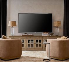 a living room with two chairs and a large television on the wall in front of it