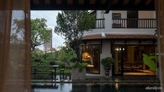 the view from inside a house looking out onto a pool and buildings in the distance