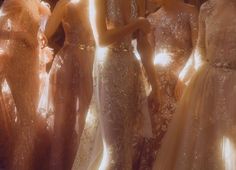 a group of women standing next to each other wearing dresses with sequins on them