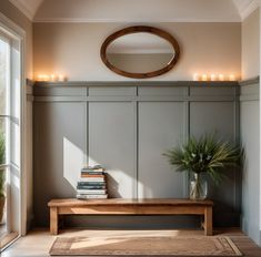 a wooden bench sitting under a round mirror