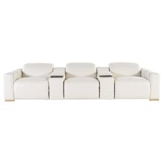 a white leather couch with four reclinings on the back and two end tables