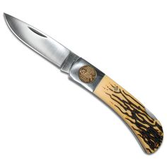 a knife that is sitting on top of a white surface with black and brown designs