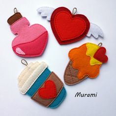 four felt ornaments with hearts, cupcakes and other items