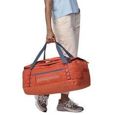 a man carrying a duffel bag with the word patagonia on it