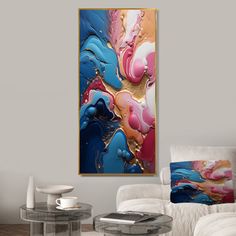 an abstract painting hangs on the wall next to a white chair and coffee table in a modern living room