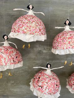 four hanging ornaments made to look like ballerinas with pink and white flowers on them