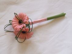 a bouquet of pink flowers sitting on top of a white sheet