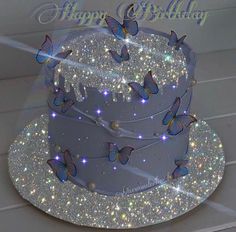 a birthday cake decorated with butterflies and sparkles