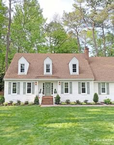 a white house in the middle of a lush green yard