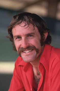 a close up of a person wearing a red shirt with a moustache on