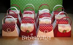 several red and white bags are lined up on a table with green wall behind them