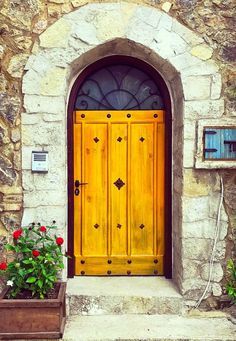 a yellow door with two planters in front of it