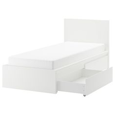 a white bed with two drawers on the bottom and one drawer open to reveal a mattress