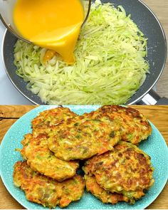 some food is on a blue plate and next to a bowl with orange juice in it