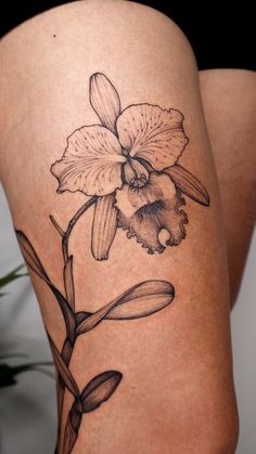 a woman's thigh with a flower tattoo on it