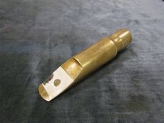 an old brass lighter is laying on a gray carpeted surface with a hole in the middle