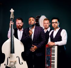 a group of men standing next to each other holding musical instruments