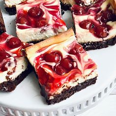 several desserts are arranged on a white platter with red and white toppings