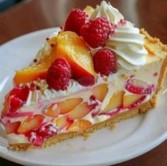 a piece of pie on a plate with raspberries and peaches