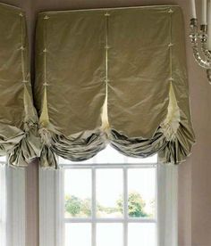 a window with curtains and chandelier in front of it