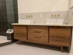 a bathroom with two sinks and a walk in shower next to a tiled tub area