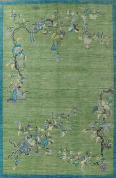 a green rug with blue border and flowers on it