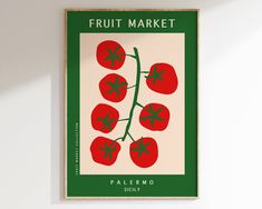 a poster hanging on the wall in front of a white wall with green trim and four red tomatoes