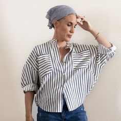 a woman wearing a blue and white striped shirt with a turban on her head