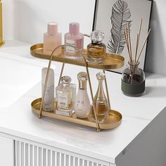 two tiered trays with bottles and candles on top of a white countertop