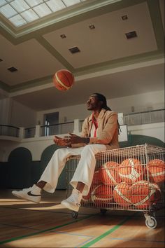 a man sitting on top of a shopping cart next to a basketball