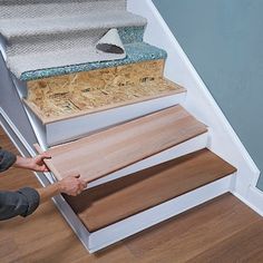 a man that is standing on some stairs with his feet in the floor and handrails