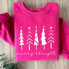 This Merry and Bright sweatshirt in Hot Pink is perfect for this holiday season whether you are cozying up with a good book or a holiday movie, going to a holiday function or getting your Christmas tree, this cozy sweatshirt is a great choice and makes a beautiful gift too. Check out the rest of our store here--> https://coastcountrydesign.etsy.com These garments are made from polyester and cotton. This combination helps designs come out looking fresh and beautiful. The collar is ribbed knit, so it retains its shape even after washing. There are no itchy side seams on these sweaters.  .: 50% cotton, 50% polyester (fiber content may vary for different colors) .: Medium-heavy fabric (8.0 oz/yd² (271 g/m .: Classic fit .: Tear-away label .: Runs true to size CARE INSTRUCTIONS:  * Turn garment Puff Vinyl Shirt Ideas Christmas, Christmas Sweat Shirts, Merry And Bright Sweatshirt, Pink Christmas Sweatshirt, Cricut Sweatshirt Ideas Women Trendy, Cricut Christmas Sweatshirts, Cute Christmas Sweatshirts, Pink Christmas Sweater, Merry Sweatshirt