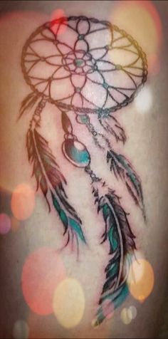 a woman's back with a tattoo on it that looks like a dream catcher