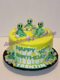 an alien themed birthday cake with green and yellow frosting