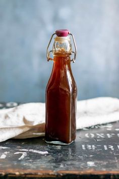 a bottle filled with sauce sitting on top of a table