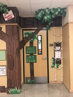 the entrance to a classroom decorated with paper mache trees and ropes hanging from the ceiling