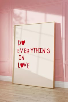 a framed poster with the words do everything in love on it against a pink wall