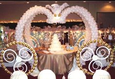 an elaborately decorated table with chairs and a cake in the shape of a heart