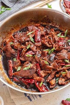 a pan filled with meat and vegetables on top of a table