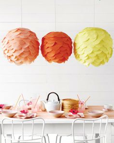 paper lanterns are hanging from the ceiling above a table